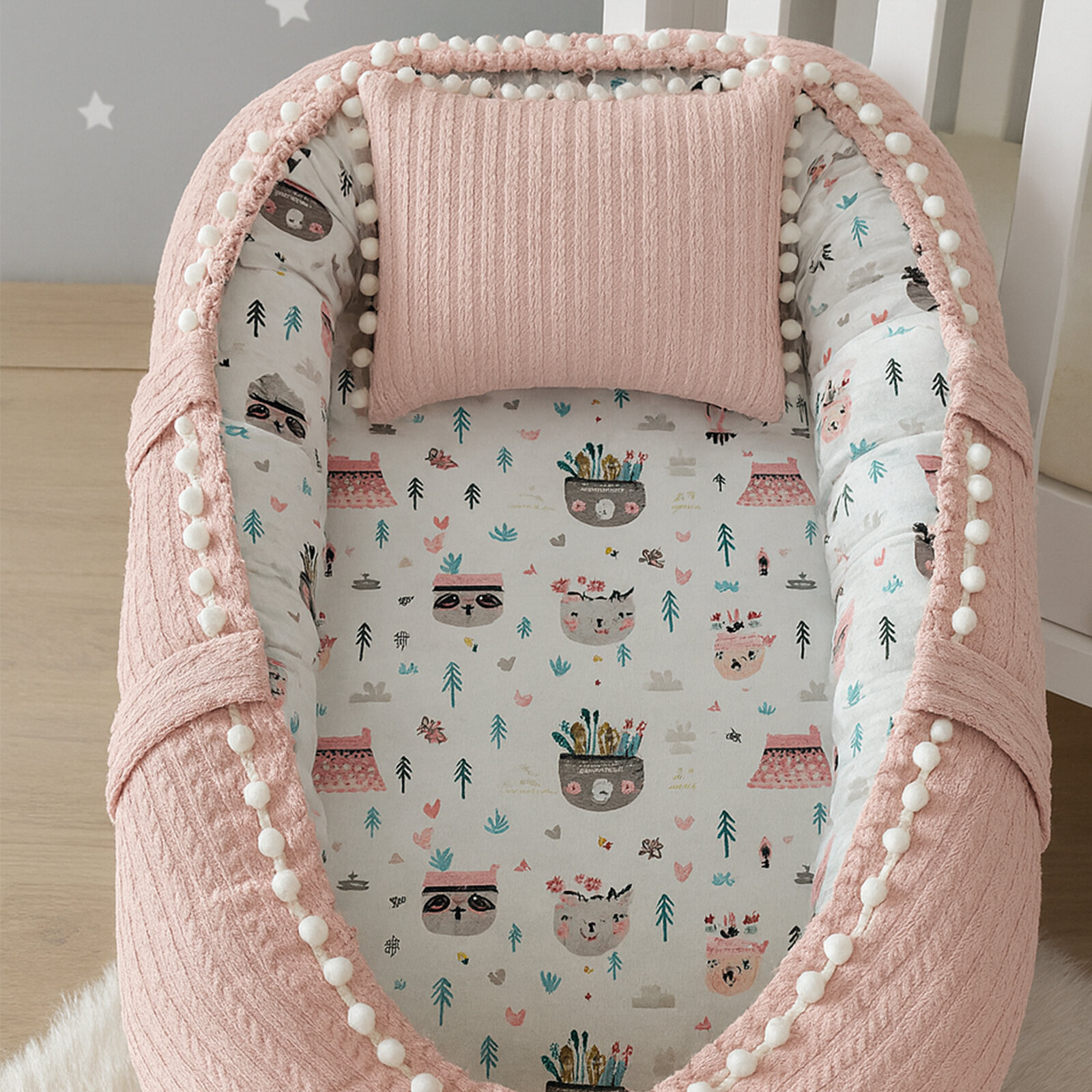 Pudra Pembe Örgü Kumaş Babynest – Desenli İç Yüzey, Ponpon Detaylı & Yastıklı Bebek Yatağı